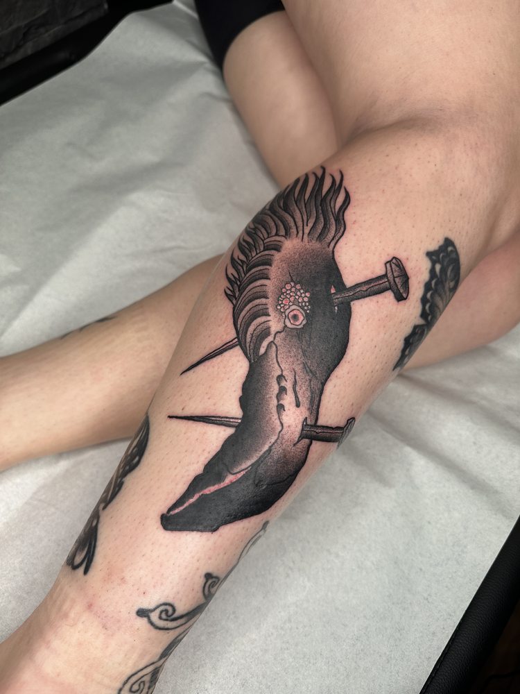 Blackwork bird pierced by nails, forearm piece