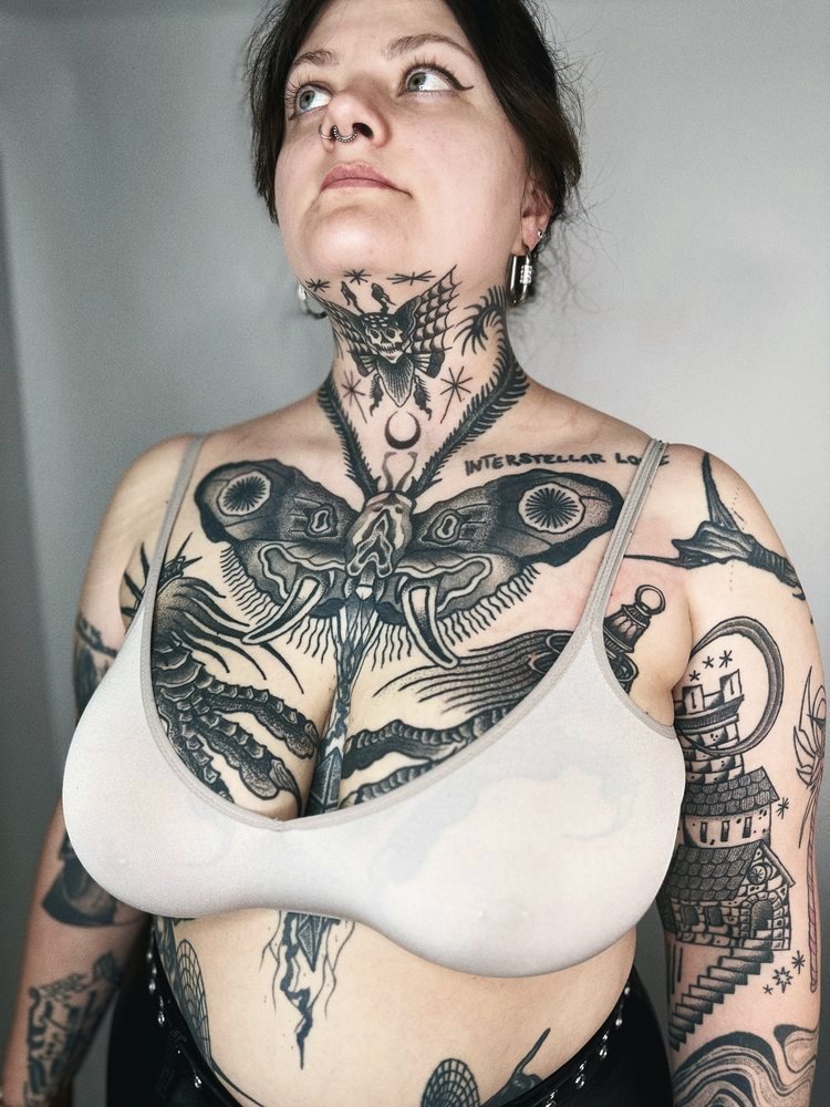 Large blackwork moth piece across the chest and neck