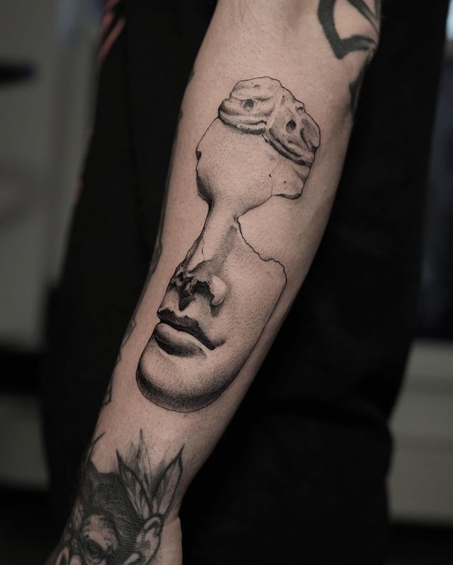 Fine line broken statue face tattoo